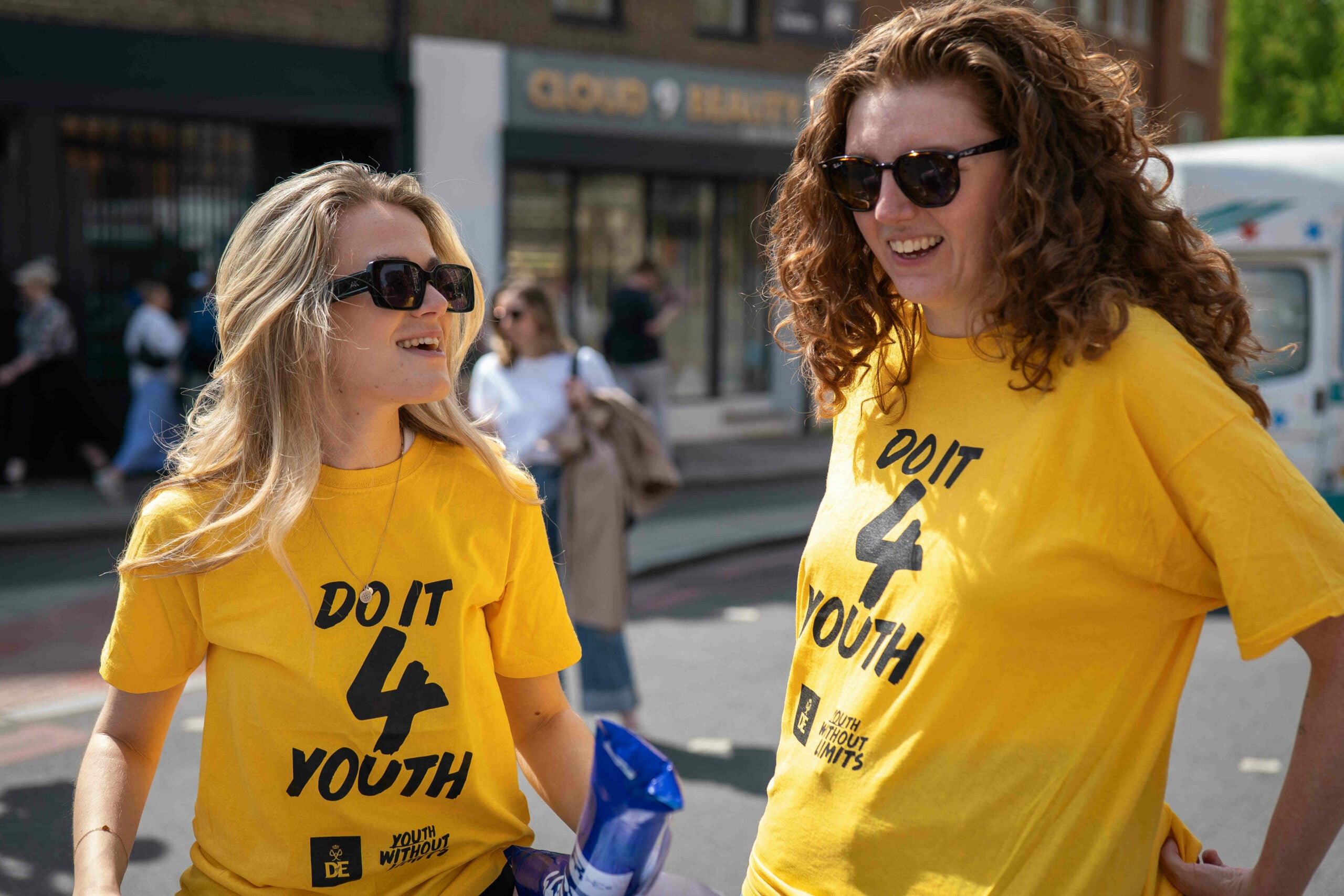Two people smiling and wearing yellow t-shirts that say 