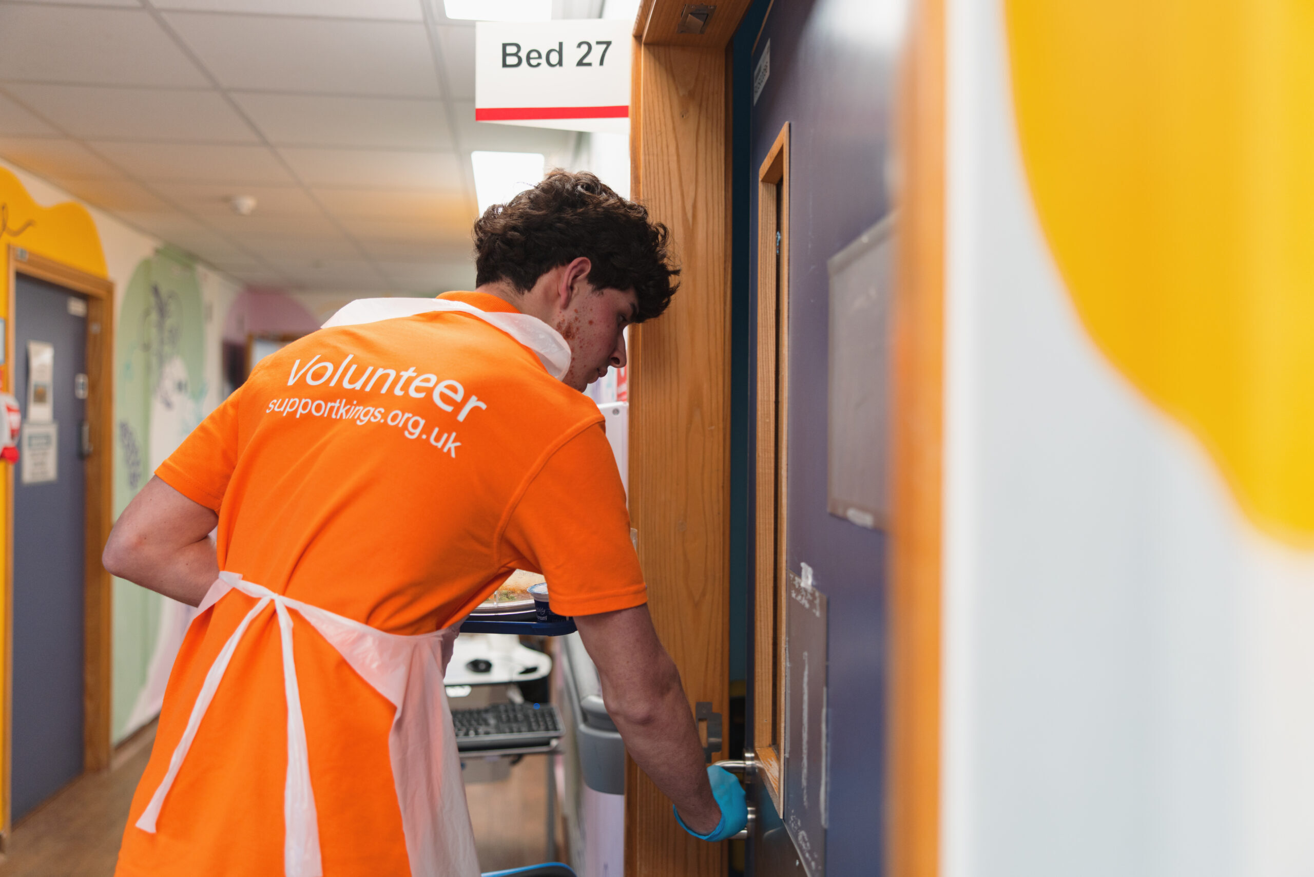 Volunteer delivering a meal to a hospital room.