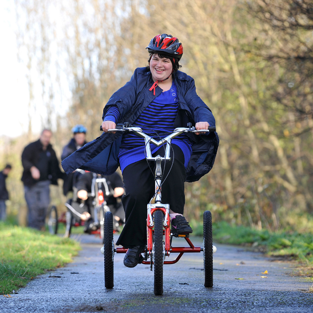 Young woman with additional needs cycling