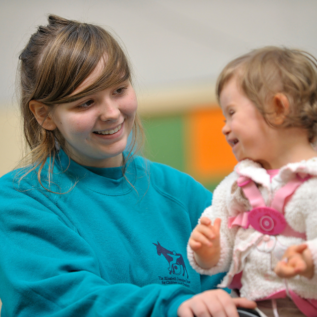 Young woman volunteering with child with additional needs