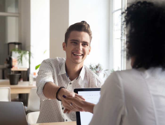 Young male being interviewed shaking hands with interviewer