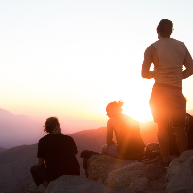 Group of people on a hill watching sunset