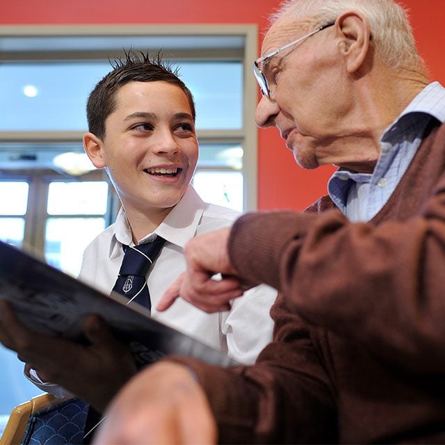 A young man talking enthusiastically with older man