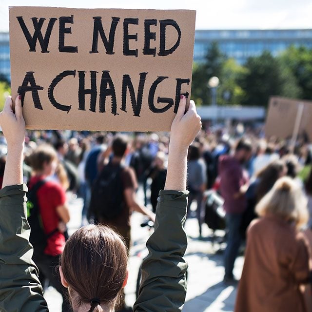 Young person with cardboard sign at protest