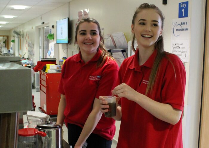 Two young DofE volunteers in NHS hospital wearing red tshirts