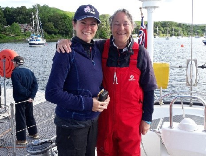 Two women on sailboat in overalls