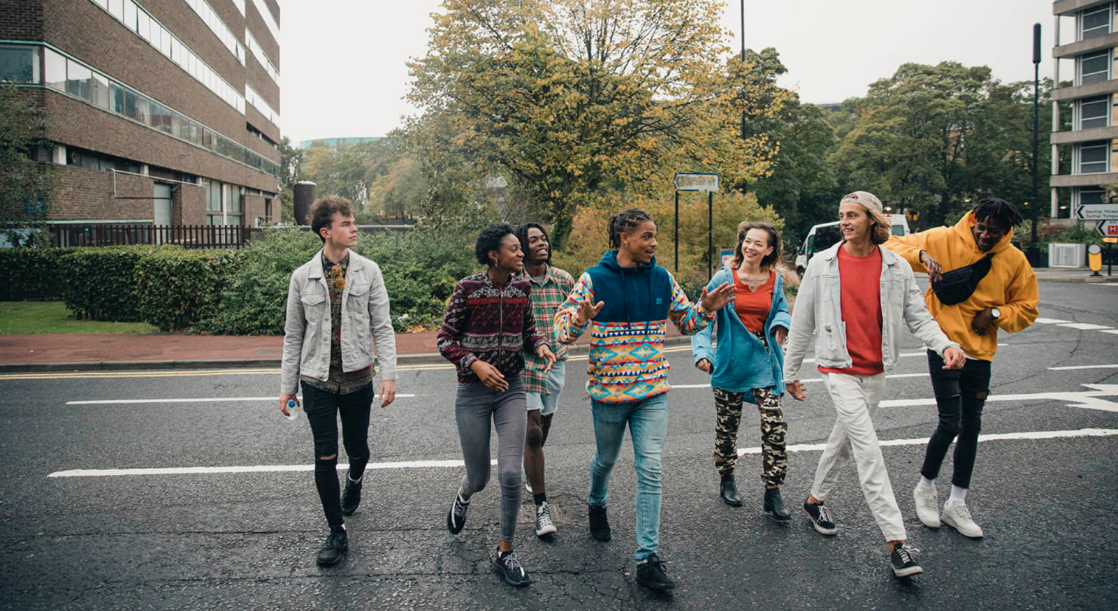 Group of happy and diverse young people walking on the street