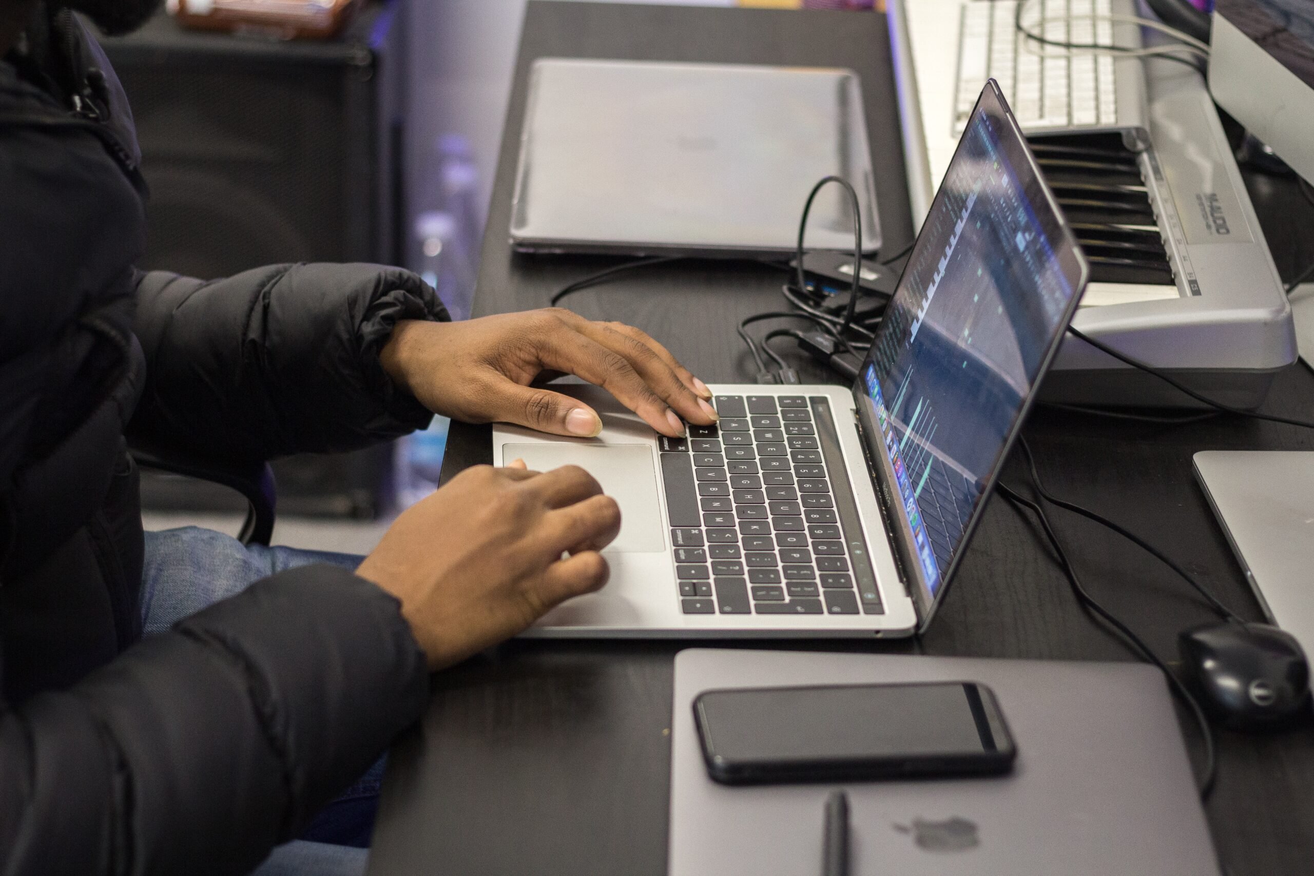 Two hands on a laptop editing an audio file.
